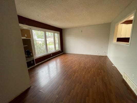 Empty room with wooden floor and window.