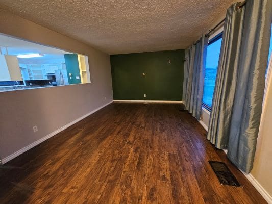Empty room with wooden floor and window.