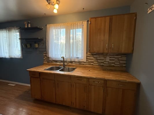 Wooden kitchen counter with sink and shelves.