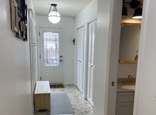 Hallway with bench, closet, and bathroom entrance.