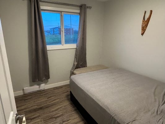 Small bedroom with bed and window.