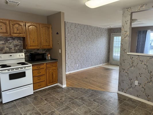 Kitchen and dining area with floral wallpaper.