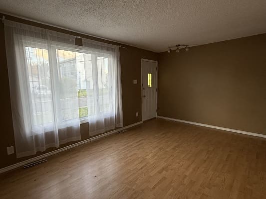 Empty room with wooden floor and window.