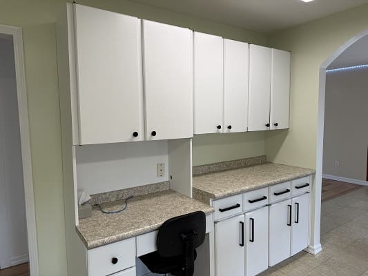 White kitchen cabinets with granite countertops.