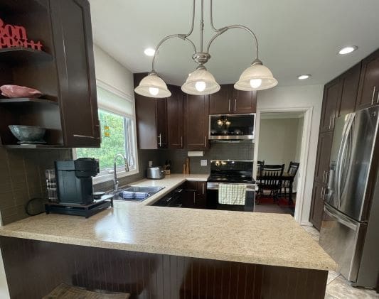 Modern kitchen with dark cabinets and appliances.