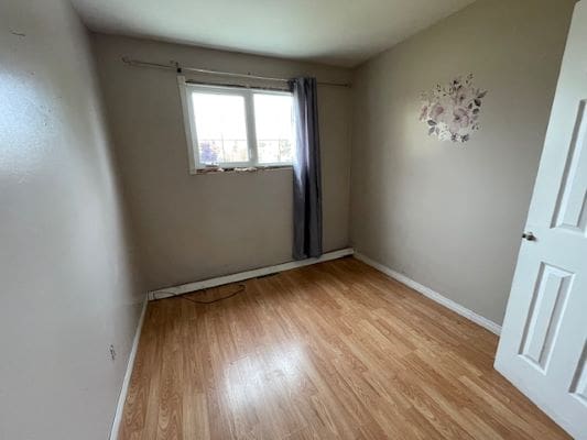 Empty room with wooden floor and window.