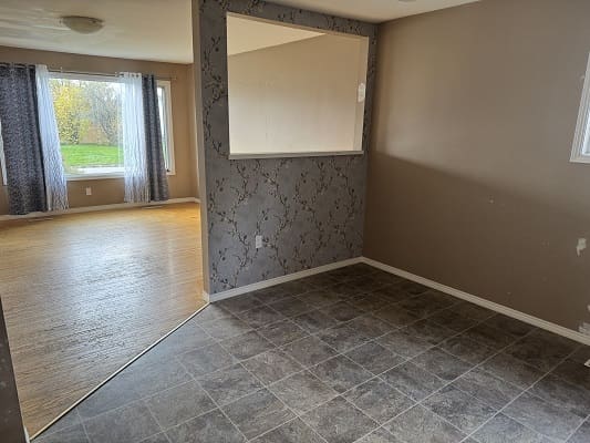 Empty room with two-tone flooring transition.