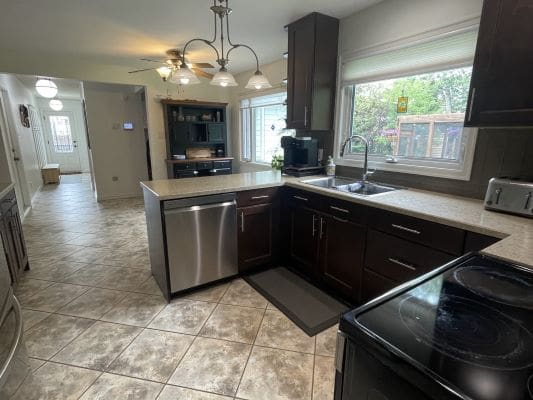 Modern kitchen with dark cabinets and appliances.