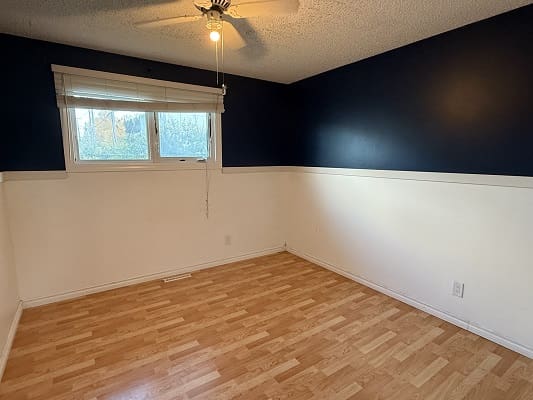 Empty room with wooden floor and window.