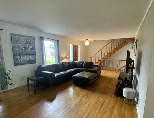 Spacious living room with staircase and sofa.
