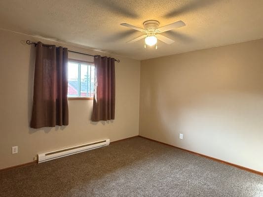 Empty room with window and ceiling fan.