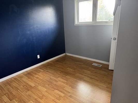 Empty room with wooden floor and window.