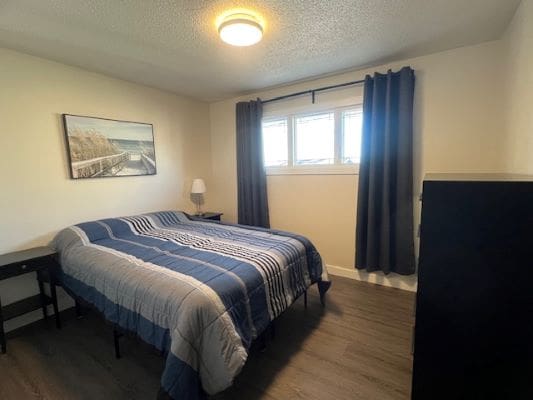 Small bedroom with blue-striped bedspread.