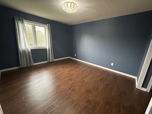Empty room with wooden floor and window.