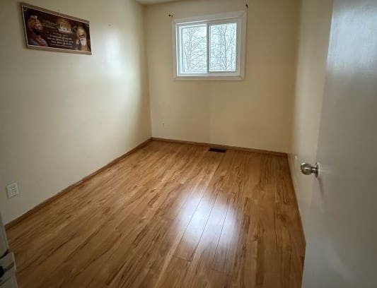 Empty room with wooden floor and window.