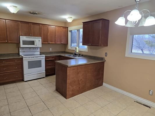 Kitchen with wooden cabinets and tiled floor.