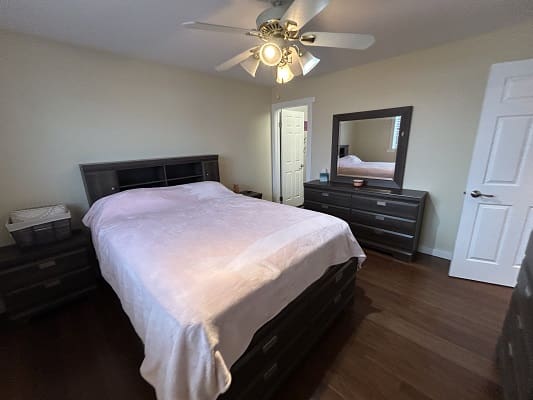 Bedroom with bed, dresser, and ceiling fan.