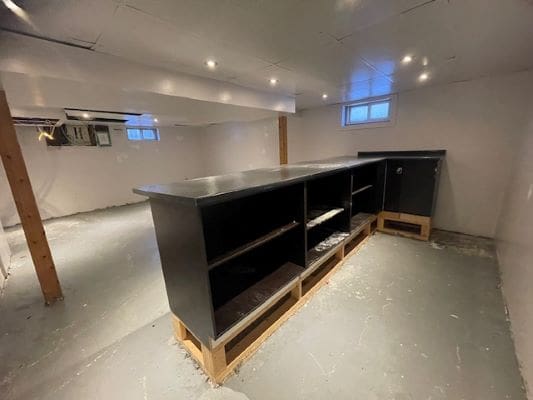 Basement with shelves and overhead lighting.