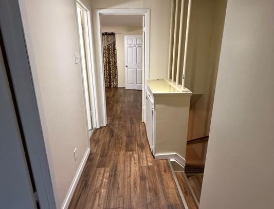 Hallway with wooden floor and white walls.