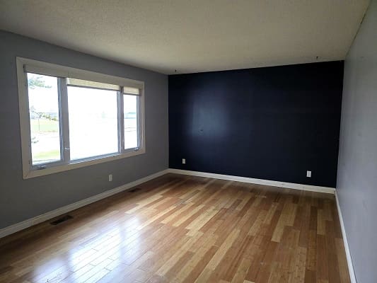 Empty room with wooden floor and window.