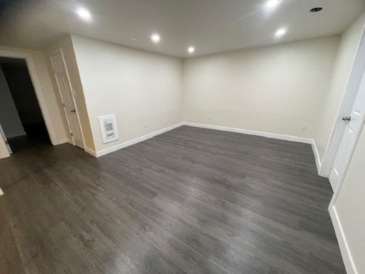 Empty room with wood flooring and lights.