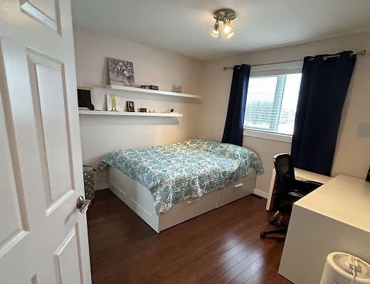 Small bedroom with bed and desk setup.