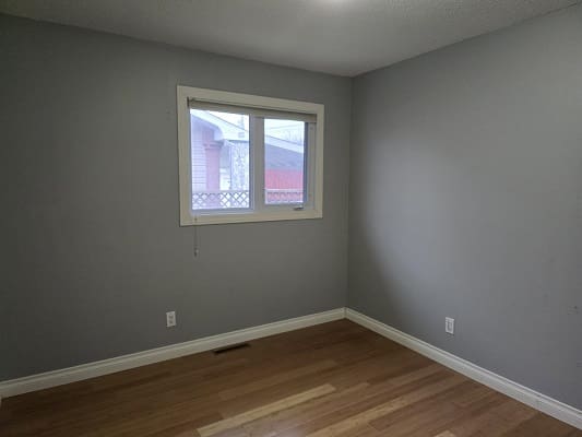Empty room with wooden floor and window.