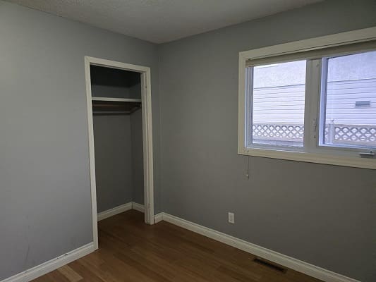 Empty room with closet and window.