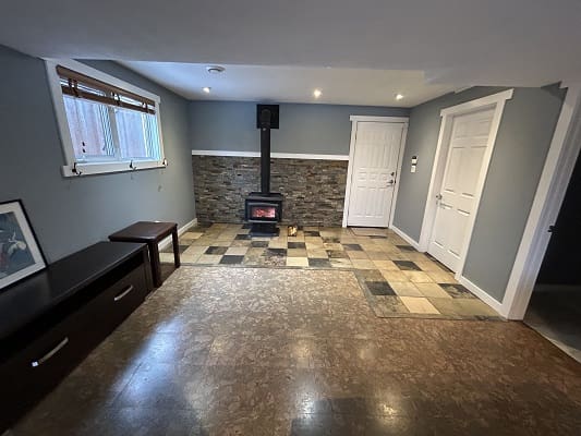 Basement room with wood stove and tiles.