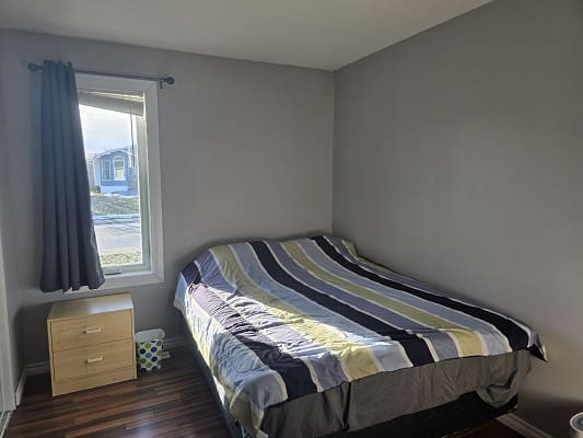 Small bedroom with bed and nightstand.
