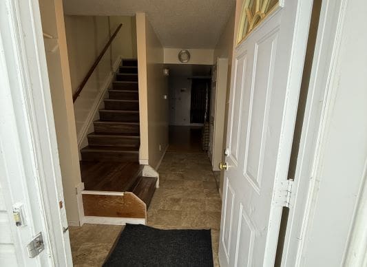 Open front door leading to staircase.
