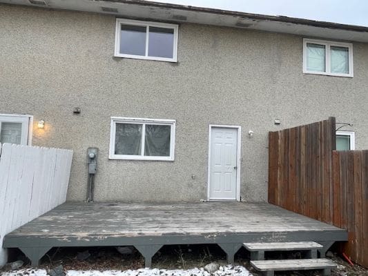 Backyard deck with wooden privacy fence.