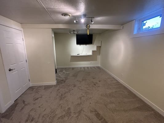Basement room with wall-mounted TV.