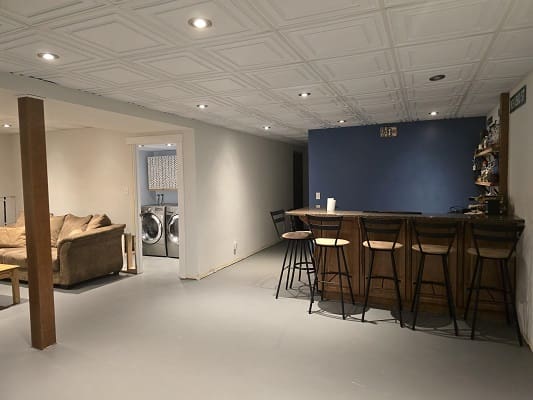 Basement lounge with bar and seating area.
