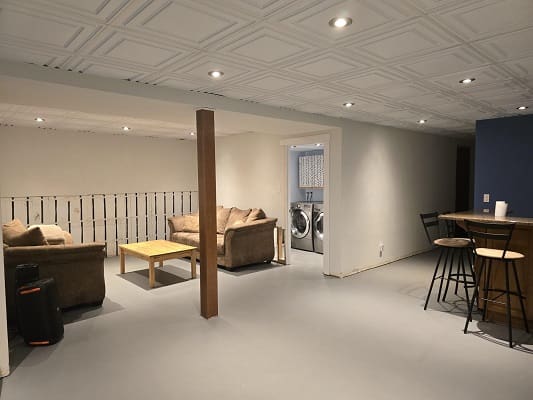 Basement lounge with bar and washer area.