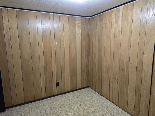 Empty room with brown wood-paneled walls.