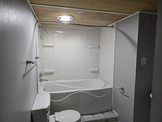 Small bathroom with bathtub and toilet.