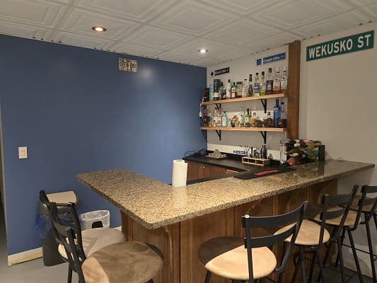 Home bar with stools and stocked shelves.