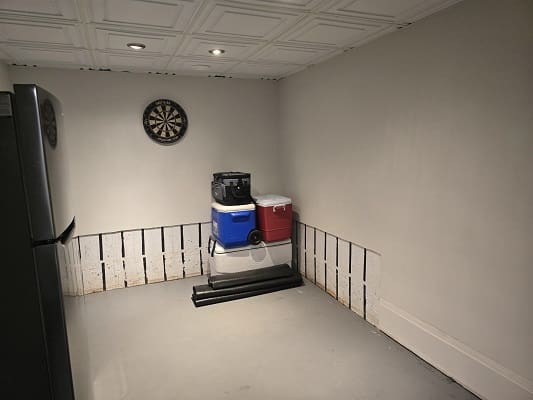 Basement room with dartboard and coolers.