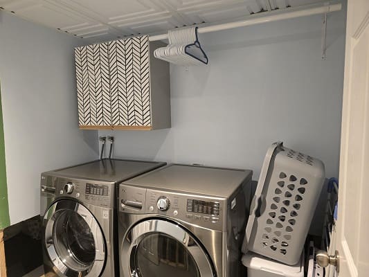 Laundry room with washer, dryer, and baskets.