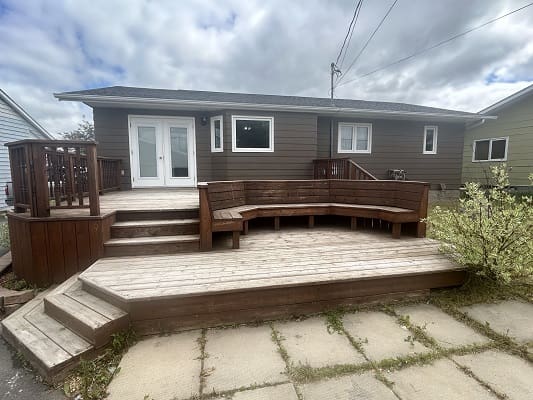 Wooden deck with bench and house exterior.