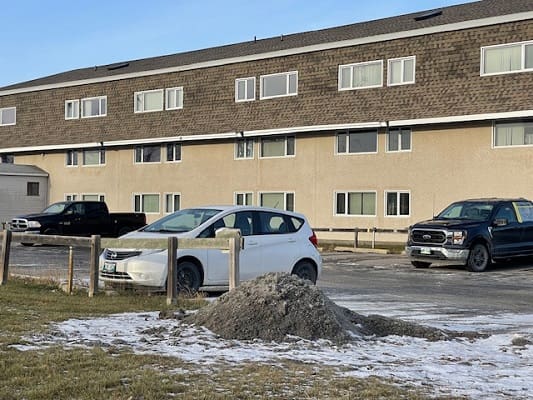 Three parked cars near a building entrance.