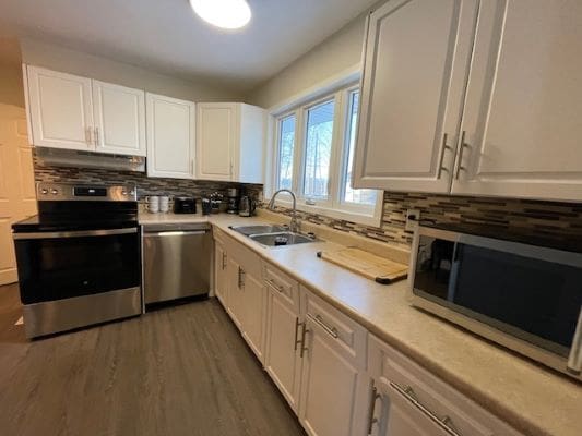 Modern kitchen with white cabinets and appliances.