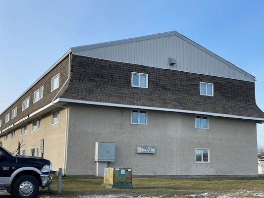 Large building with parked truck nearby.