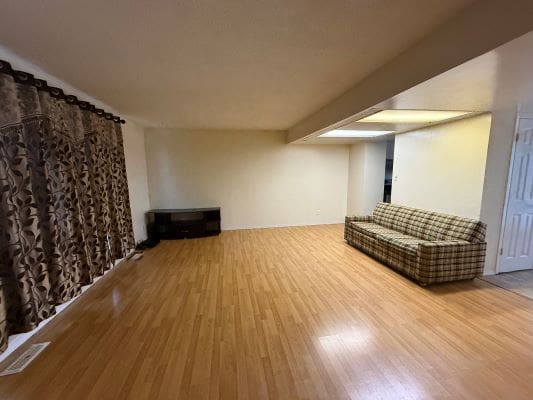 Spacious living room with wooden floor.