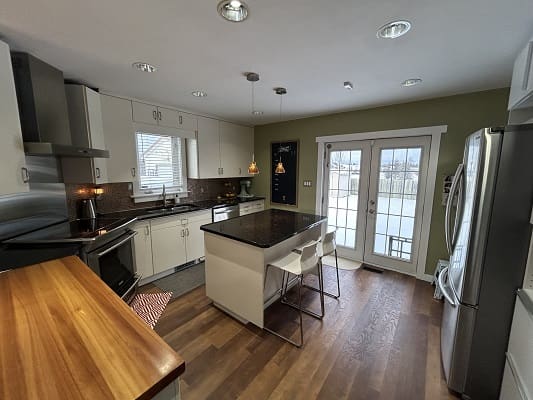 Modern kitchen with island and wooden floor.