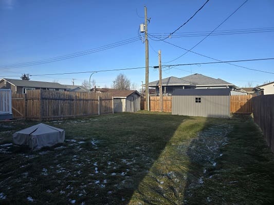 Backyard with shed and wooden fence.