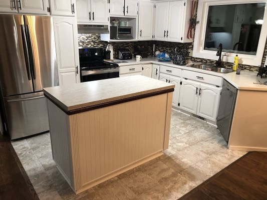 Modern kitchen with island and stainless appliances.
