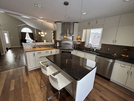 Modern kitchen with island and wooden floors.