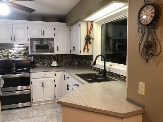Modern kitchen with white cabinets and backsplash.